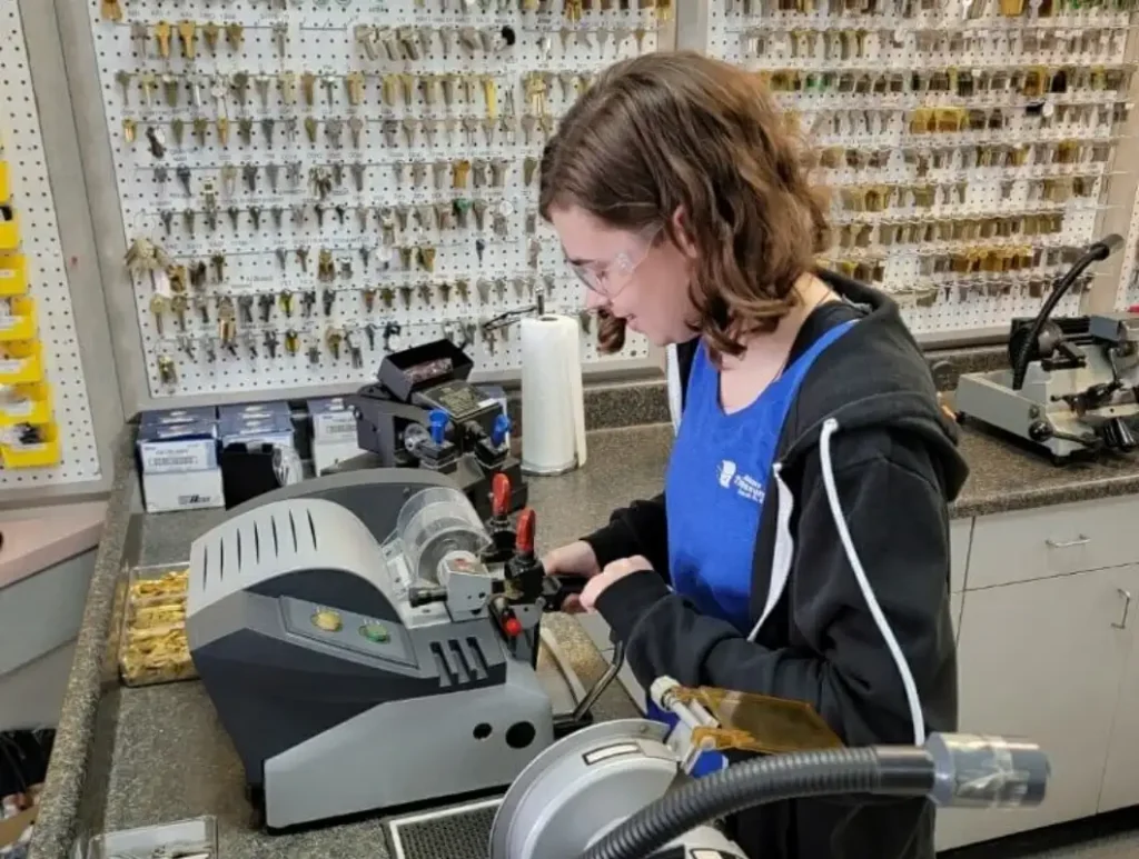 Woman operating key-cutting machine at Adams Lock & Safe